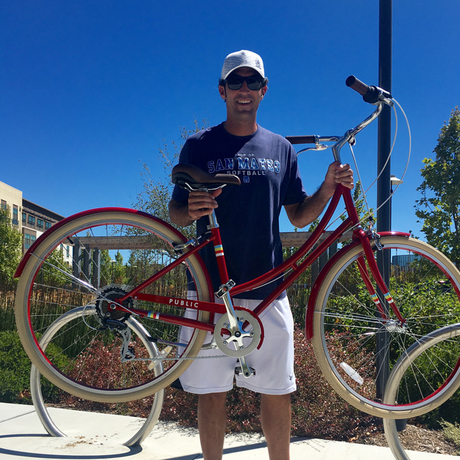 San Mateo Fire Fighter, Gino shows off a Red Hot PUBLIC bike in our raffle!